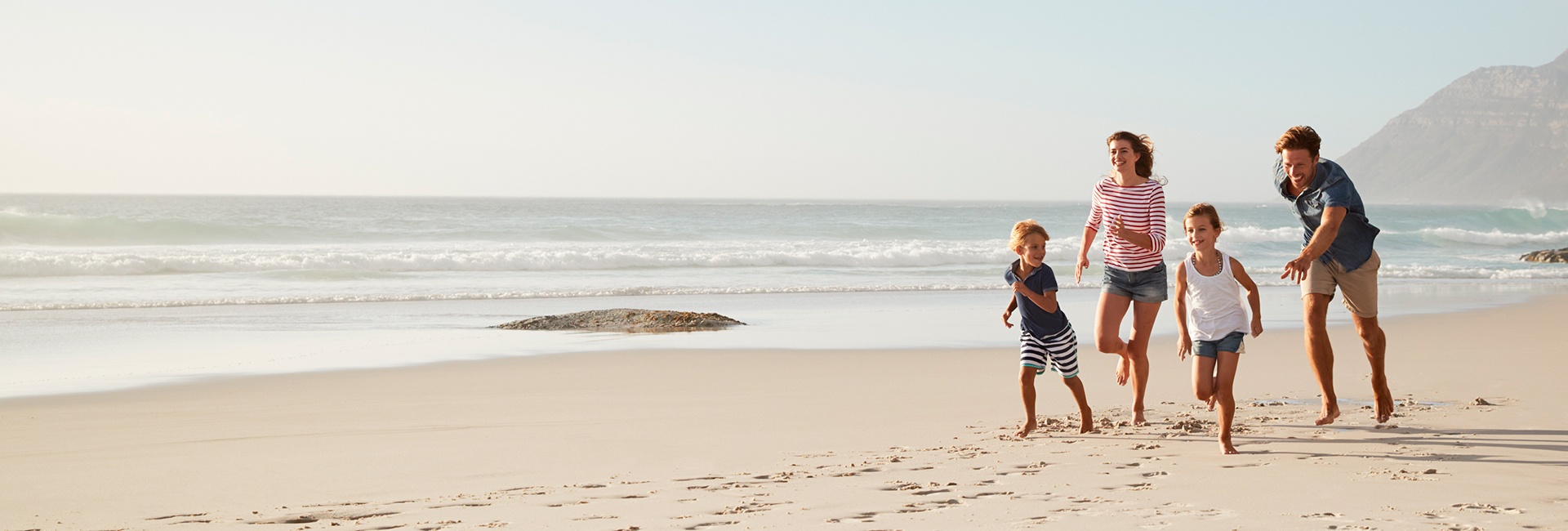 family-running-on-beach-1920x650